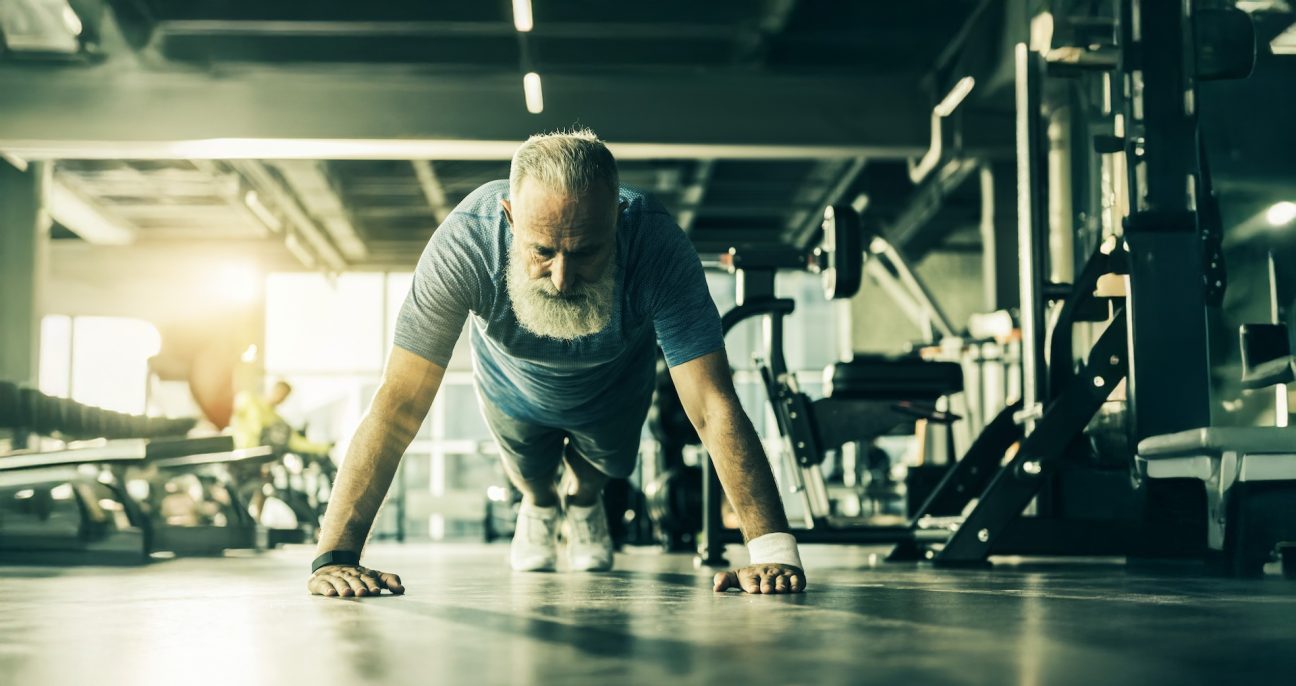 A senior man doing push ups and gaining resilience.