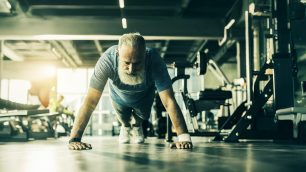 A senior man doing push ups and gaining resilience.